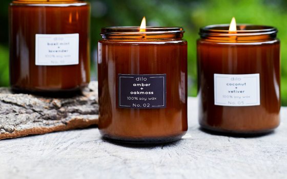 Three candles with brown glass on a table.