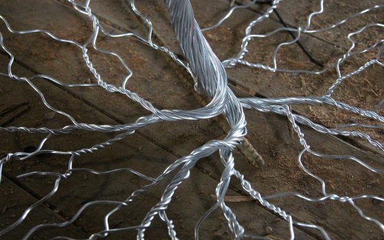 Tree trunk and roots constructed in twisted silver metal