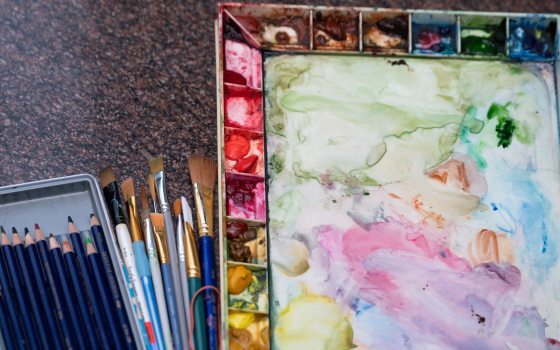 Watercolor materials, including a paint tray and brushes. 