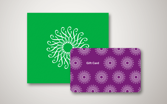 Purple gift card with white floral Longwood logo, against a green envelope with white floral Longwood logo.