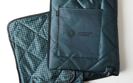 A dark teal field blanket with the Longwood Gardens logo in black. 