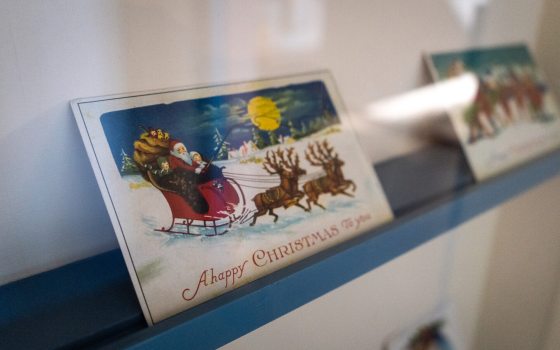 Two vintage Christmas cards on a blue ledge.
