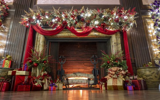 mantle and fireplace decked with red fabric swags and gilded decorations