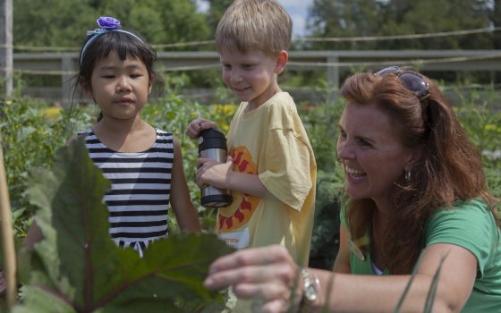 Two students look at plants in the Idea Gardens with a female Longwood Educator