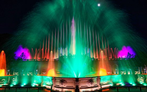 fountains in green, fuchsia, and fiery yellow-orange against a black night sky