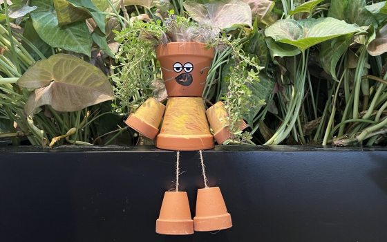 Character crafted out of small terra cotta pots plated with herbs
