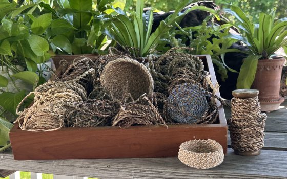 Collection of baskets made from natural materials assembled in a wooden tray.