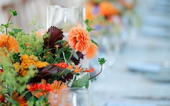 Closeup of bright fall flowers amid table settings.