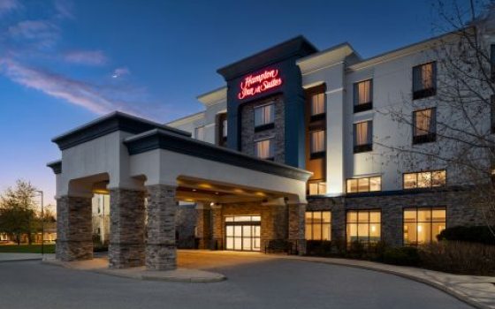 The outside of a Hampton Inn hotel at dusk. 
