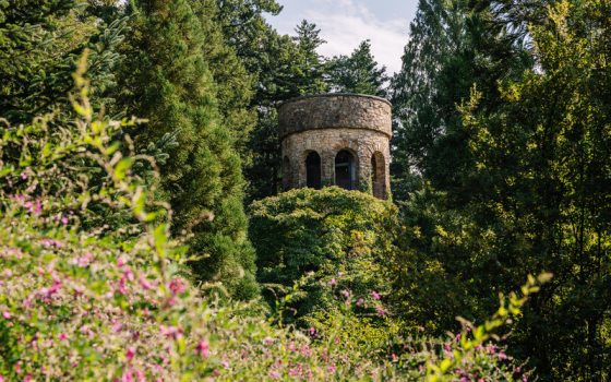 A stone tower, surrounded by tall trees, at Longwood Gardens.