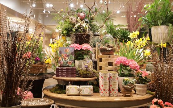 A table of merchandise, including items in floral motifs and live plants