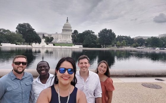a group of smiling Fellows pose for a selfie in front of the US capital building