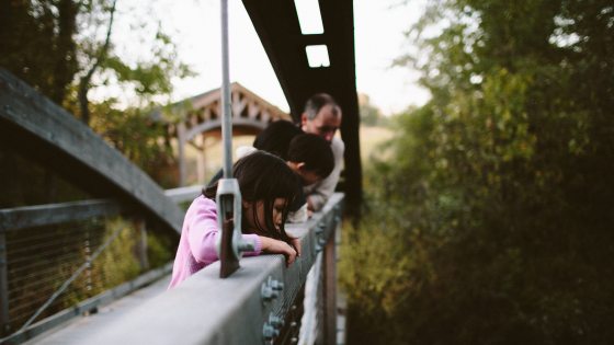 Group of kids looking over a nature bridge