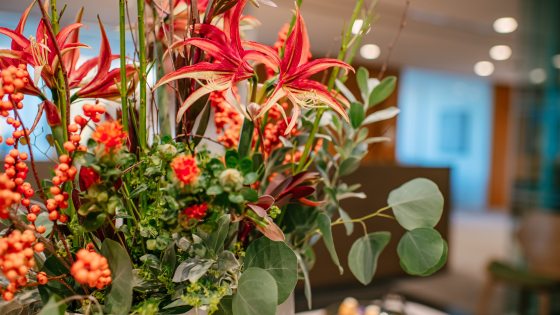 An orange themed floral arrangement on display in a classroom.
