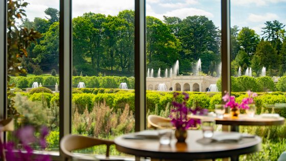 table set with flowers overlooking Longwood's Main Fountain Garden on a sunny summer day