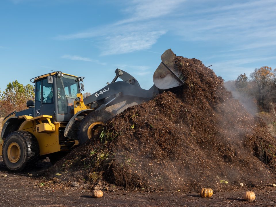 A bulldozer moving a large pile of dirt. 