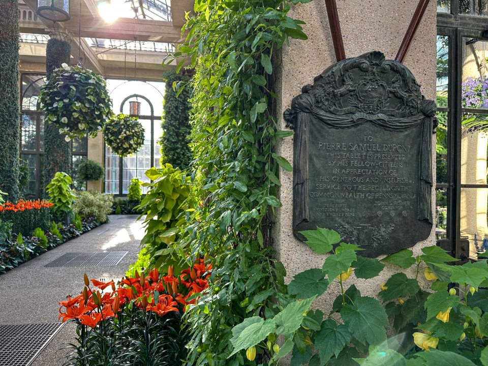 A bronze plaque with text in the Longwood Conservatory.