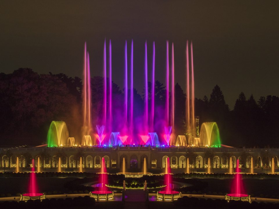 The Main Fountain Garden at Longwood with its fountains at night lit up in an array of colors.