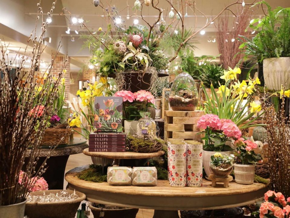 A table of merchandise, including items in floral motifs and live plants