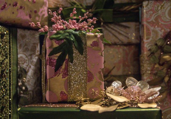 beautifully wrapped gifts using pink and green wrapping paper and ribbons and plant foliage