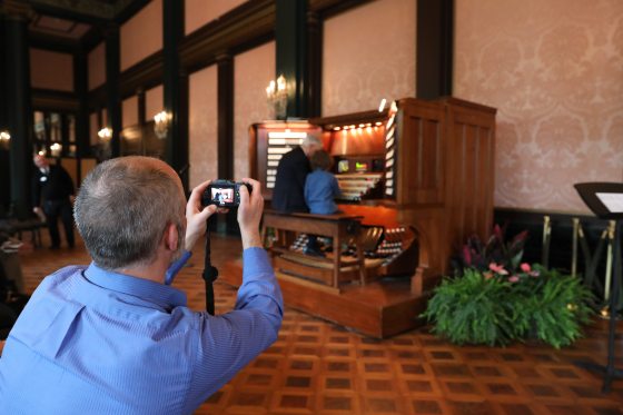 person photographing someone playing an organ