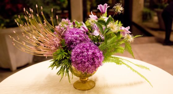 A vase of purple flowers on a table. 