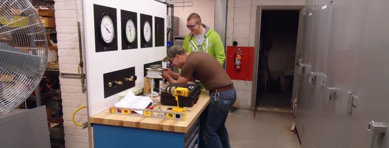a co-op student works with an adult in a workshop