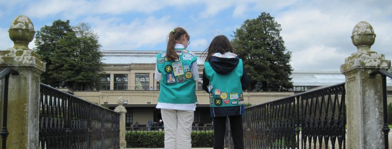 two girl scouts look with their back towards us