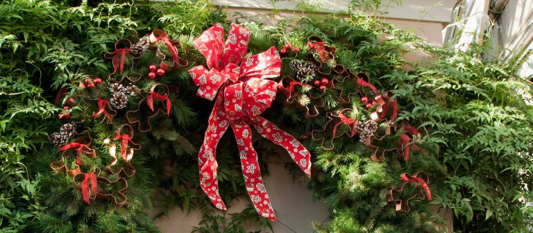 top half of a green wreath with a red bow