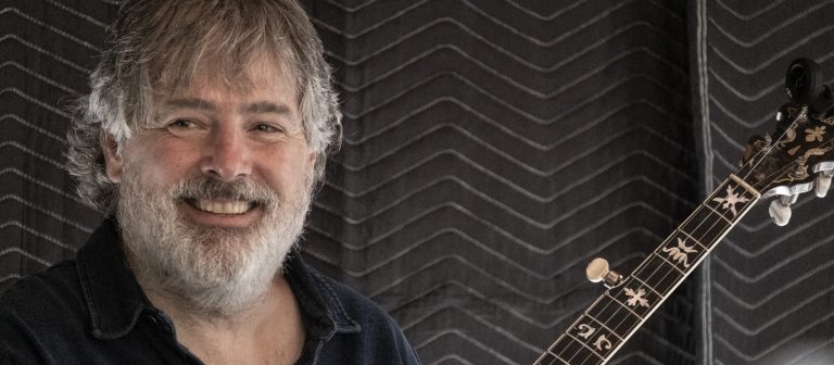 An adult holding a guitar