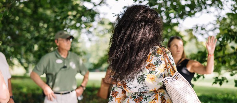 Three people talking in an outdoor garden setting