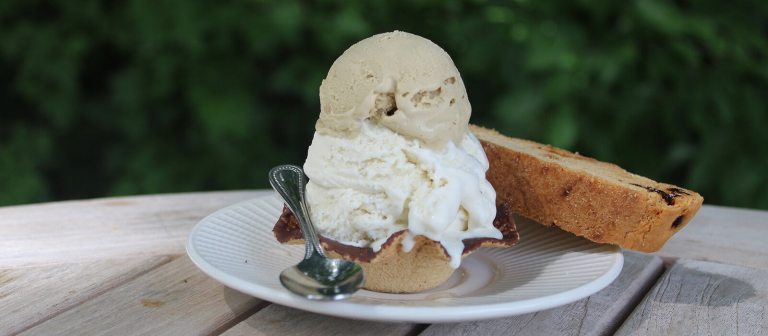 An ice cream sundae on a white plate. 