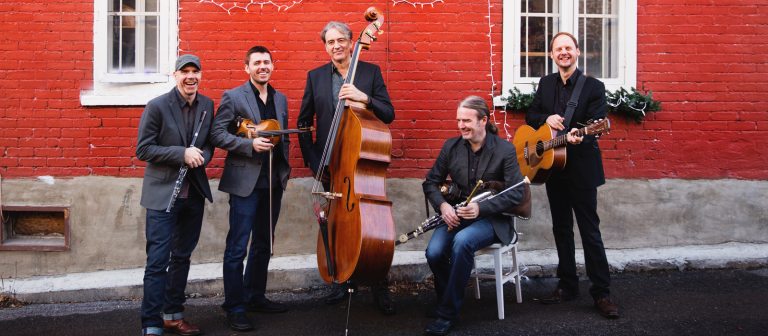 Musicians standing in front of a wall