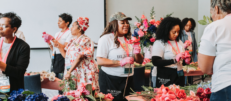 A group of people creating floral arrangements.