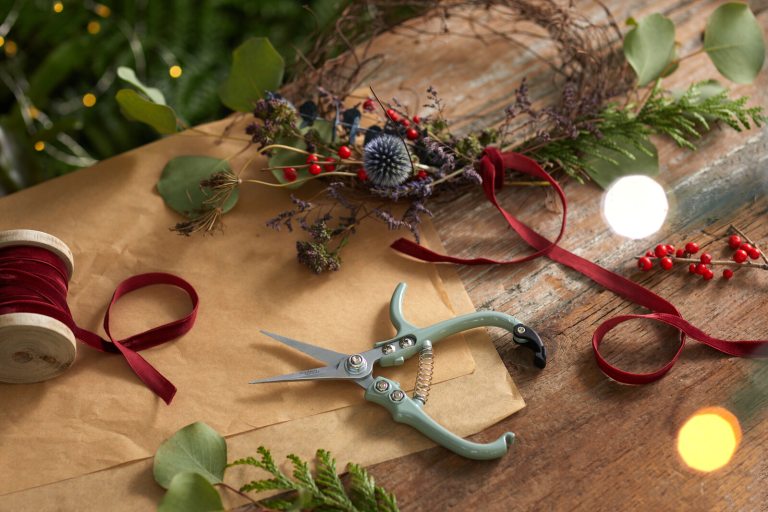 Wreath making tools laid out on a wooden table.