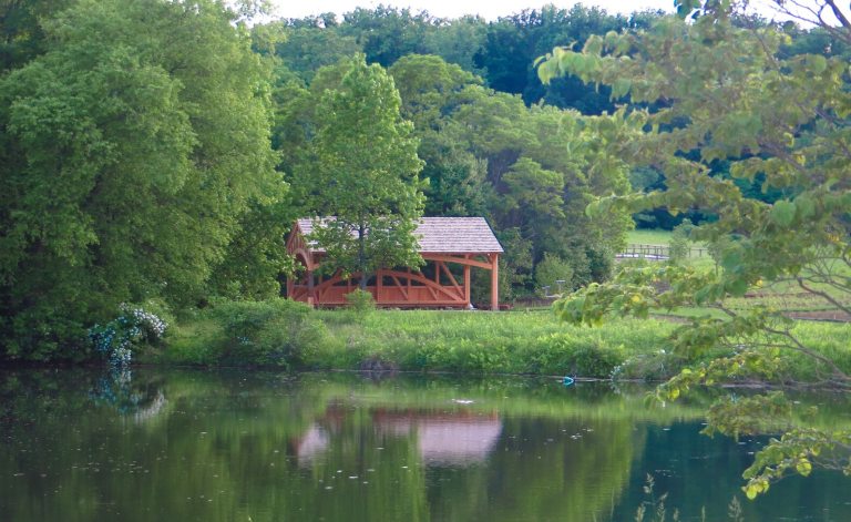 A small lake with a pavillion in the background. 