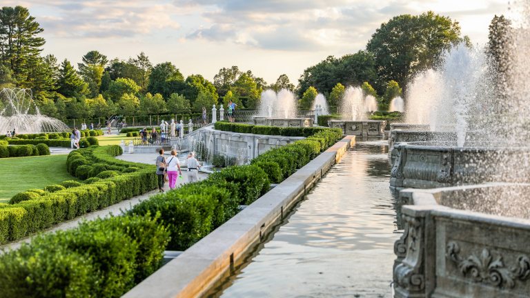 People of all ages stroll through a fountain garden.
