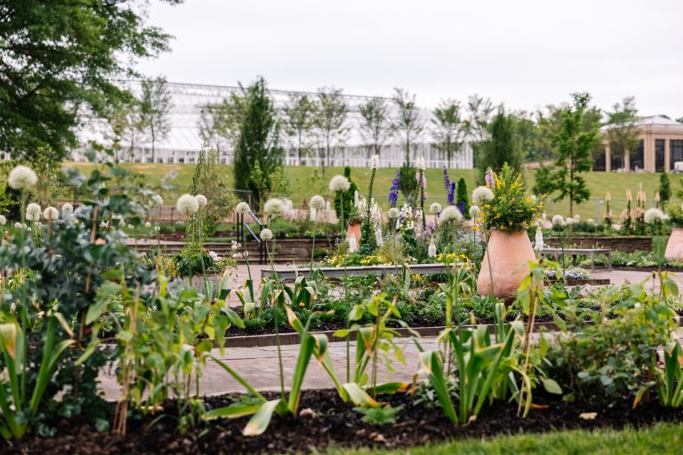 The Idea Garden at Longwood with spring plantings in the beds and the conervatory in the distance.
