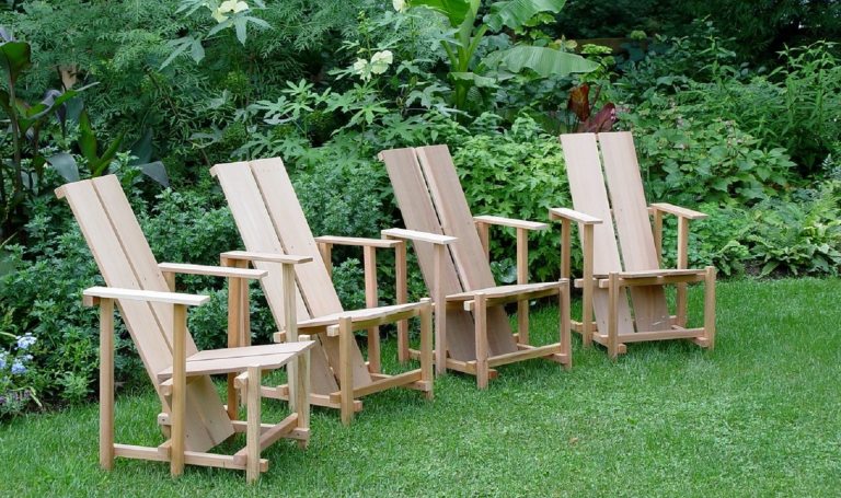 Four wooden wave hill chairs in green grass.