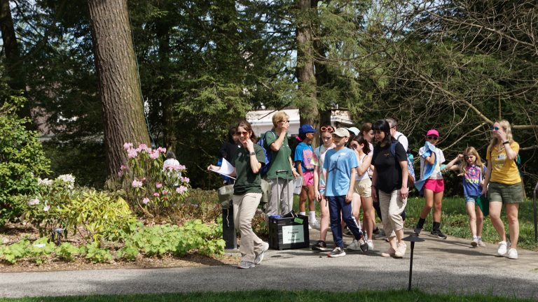 school aged children being led on a tour of gardens