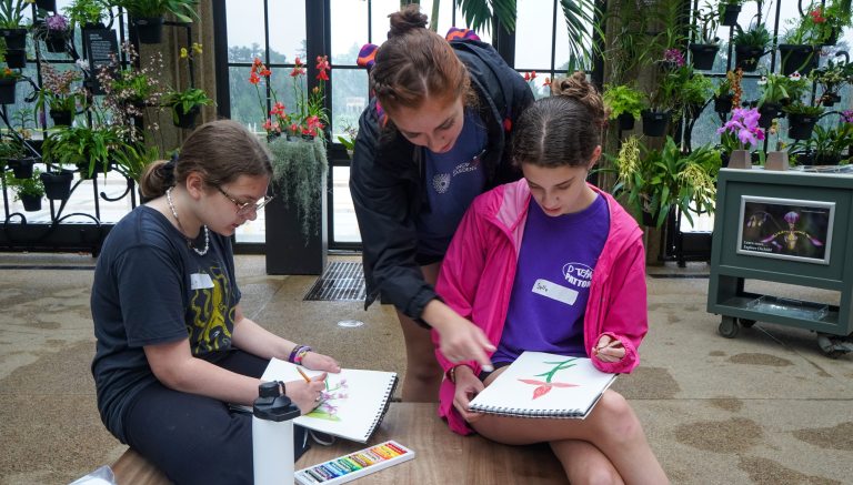 Instructor and two youth workshop students illustrating orchids