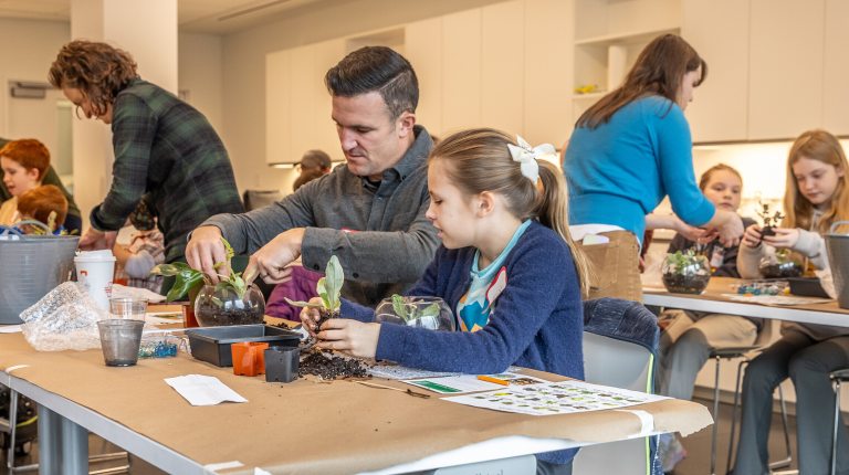 Father and daughter planting a terrarium 