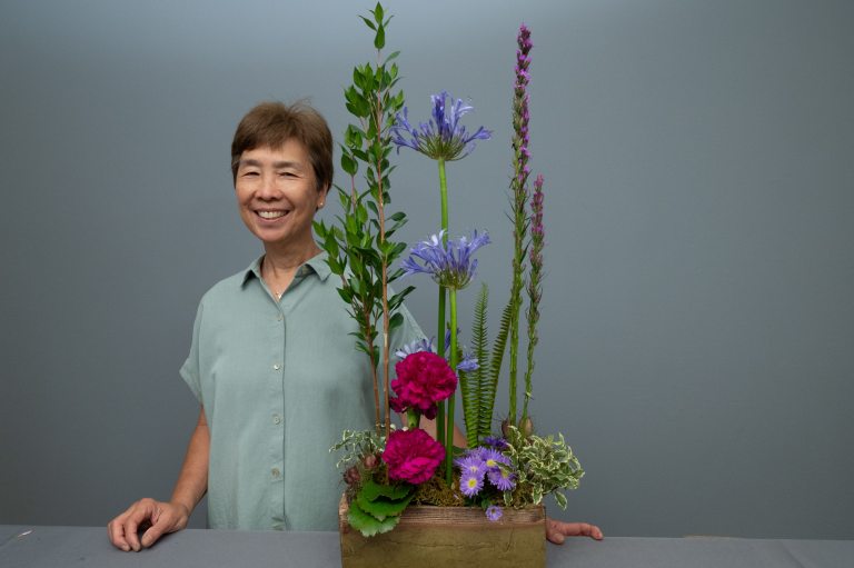 Cres Motzi standing next to a linear floral design centerpiece