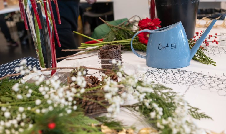 Holiday floral arrangement supplies laid out on a table.