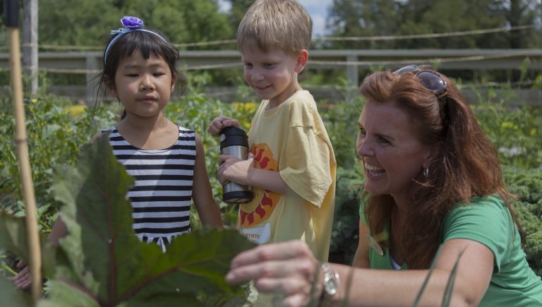 Two students look at plants in the Idea Gardens with a female Longwood Educator