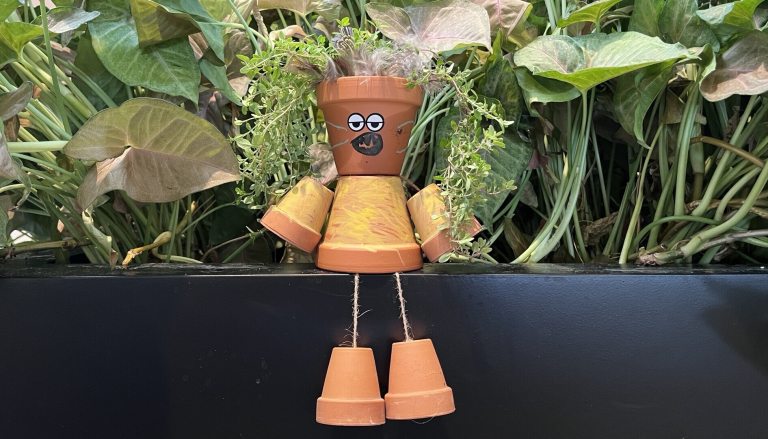 Character crafted out of small terra cotta pots plated with herbs