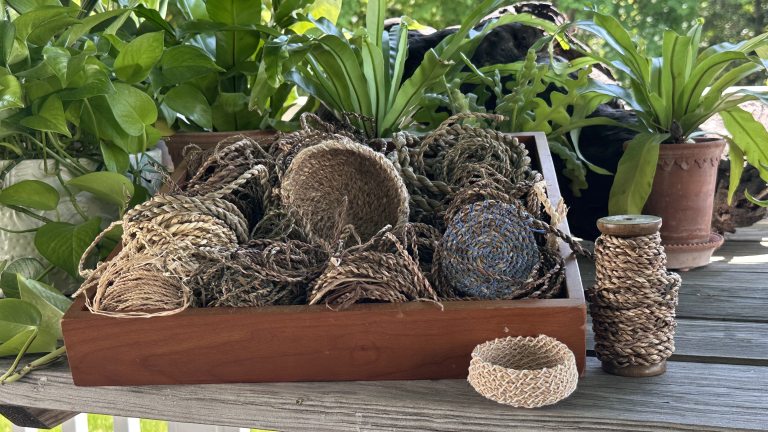 Collection of baskets made from natural materials assembled in a wooden tray.