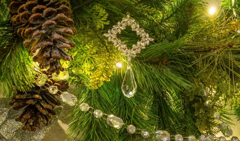 A close up of evergreen garland, decorated with pinecones and crystals.