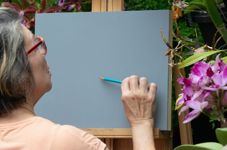 A person in front of an easel, getting ready to sketch orchids.
