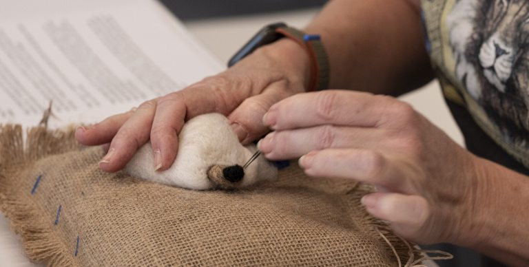 A person working on a needle felt project.